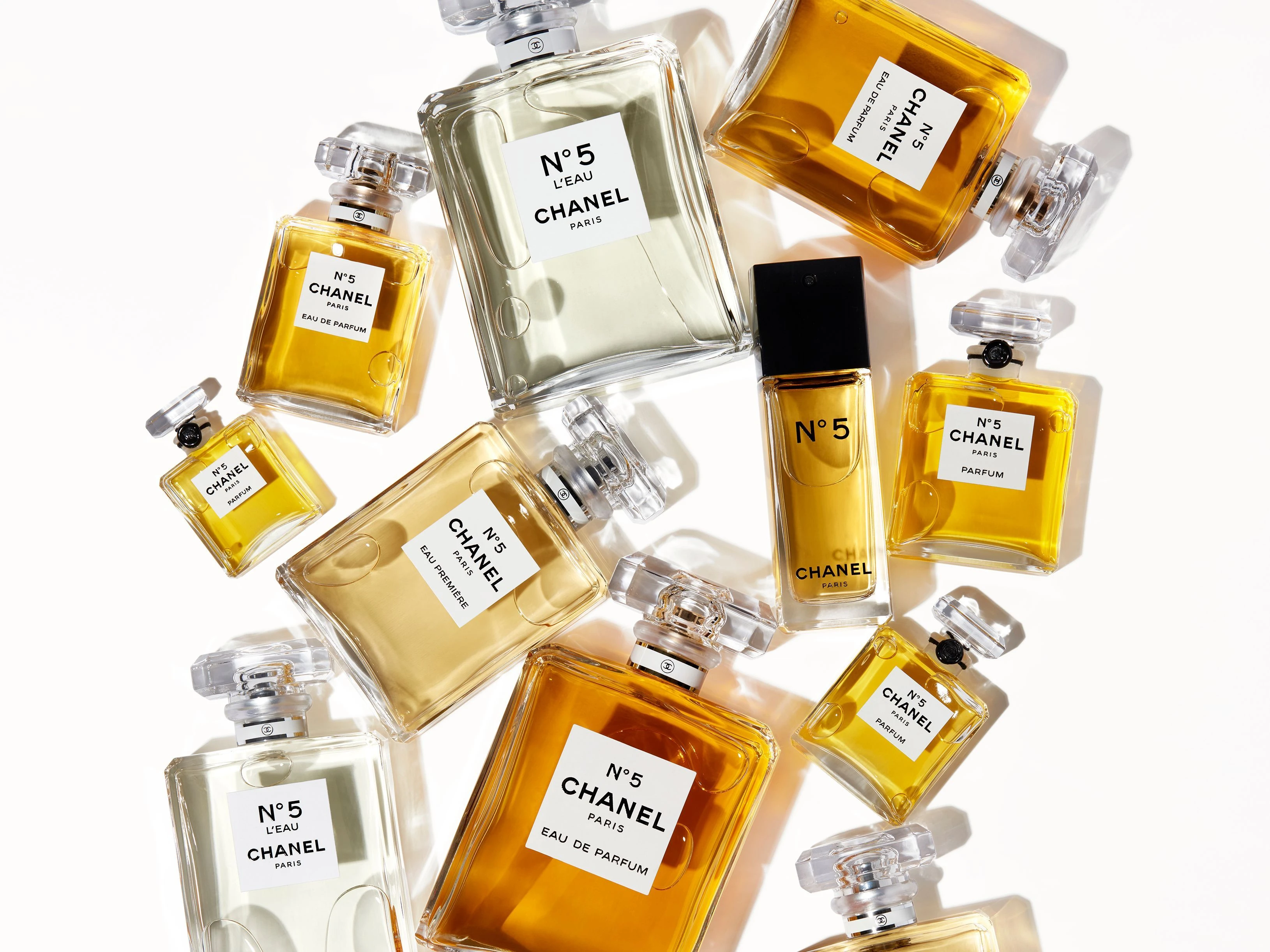 “Flacon de parfum de luxe rectangulaire en verre transparent avec bouchon élégant, issu d’une maison française emblématique.”